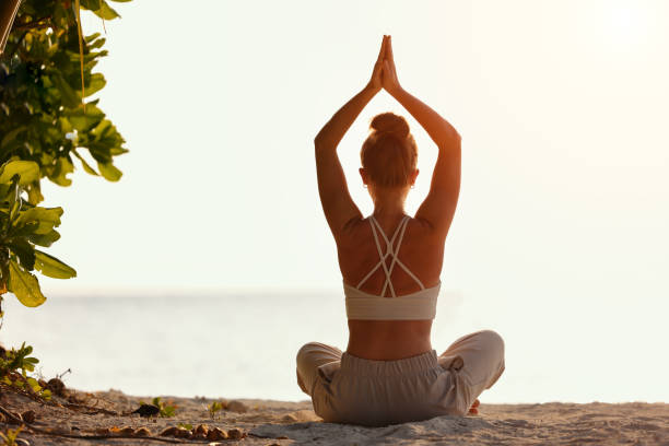 istock Woman practicing yoga on sandy beach 1312085467