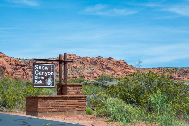 An entrance road going in Snow Canyon SP, Utah Snow Canyon SP, UT, USA - May 17 2020: A welcoming signboard at the entry point of the park snow canyon state park stock pictures, royalty-free photos & images