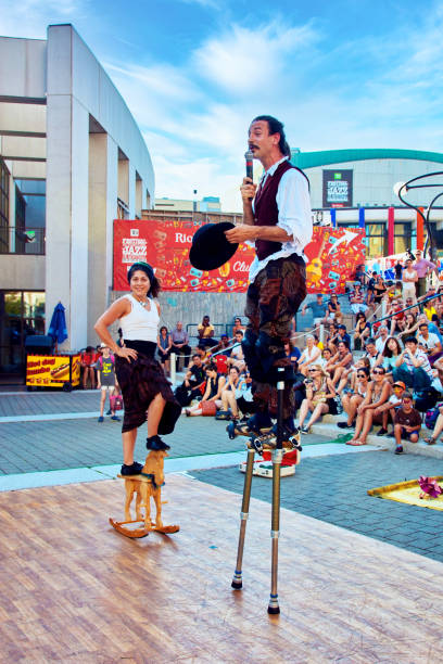 ale and female acrobats perform stilt walking on an outdoor stage at festival in montreal, quebec, canada. - traditional festival juggling women performer imagens e fotografias de stock