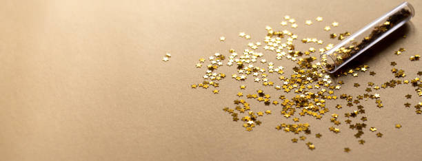 istock Golden sparkles stars on gold holiday background. Festive backdrop for your projects. 1312089027