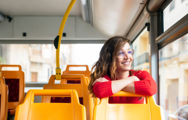A smiling young woman sitting on the public bus