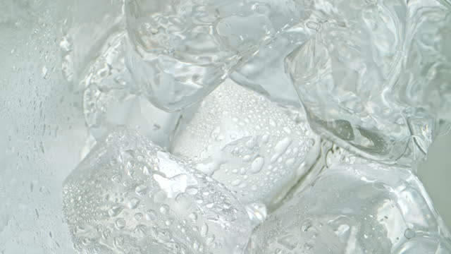 SLO MO LD Water flowing into a glass over ice cubes