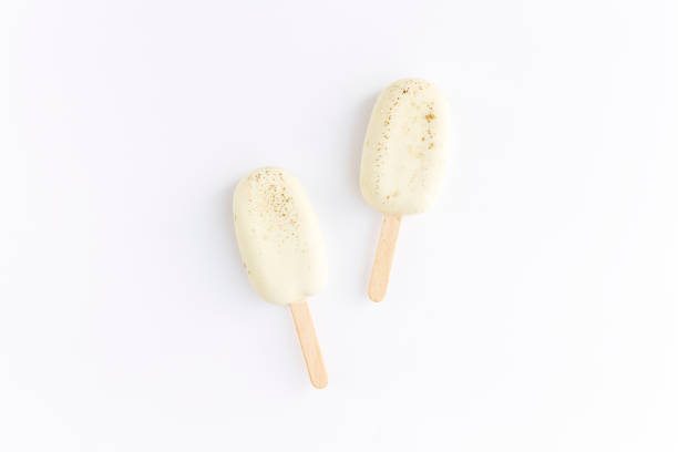 istock Flat lay with white cookie ice creams on a stick on white background 1312094640