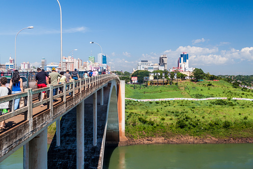 Ciudad del Este, Paraguay - Feb 7, 2015: People and vehicles cross Friendship Bridge between Brazil and Paraguay, Ciudad del Este city in the background.