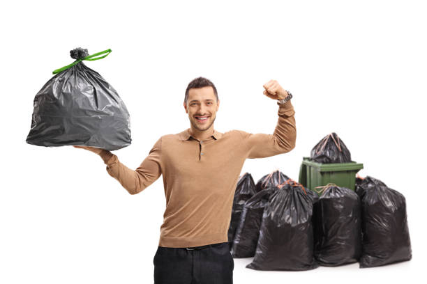 istock Young man holding a garbage bag and flexing his biceps in front of a dustbin 1312095727