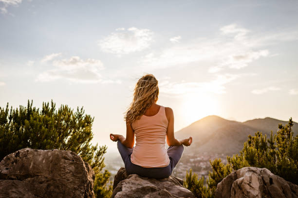 istock Young woman preforms yoga in mountains at sunset 1312096090