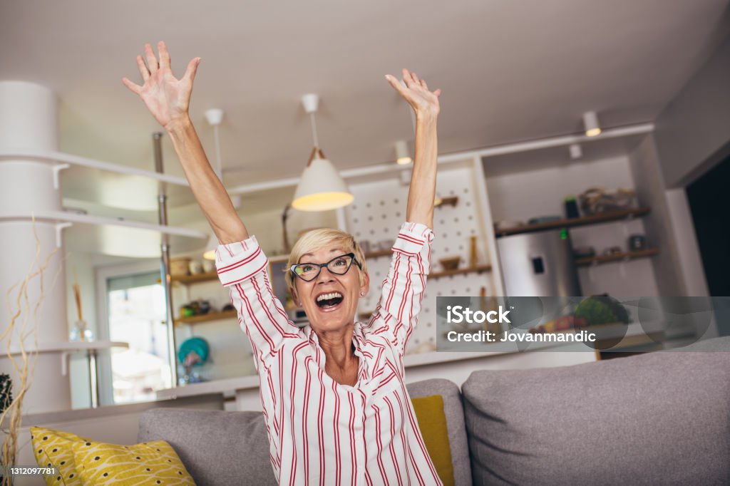 Starší žena emocionálně sleduje fotbal v televizi a slaví vítězství doma. - Bez autorských poplatků Senioři - Dospělý jedinec Stock fotka Starší žena emocionálně sleduje fotbal v televizi a slaví vítězství doma. - Bez autorských poplatků Senioři - Dospělý jedinec Stock fotka