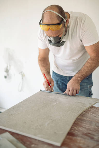 istock Professional tiler measuring tiles before cutting 1312098589