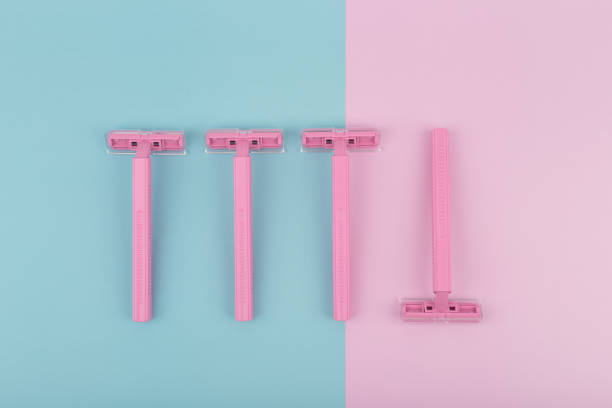Top view of pink plastic razors on pink and blue background. Concept of hygiene and depilation