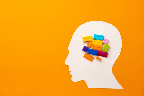 istock Papercut head silhouette with toy constructor pieces on yellow background 1312099920