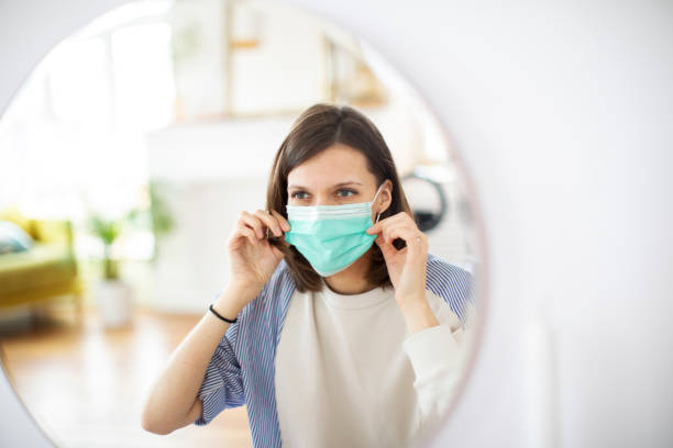 istock Young woman putting on mask before mirror 1312101541