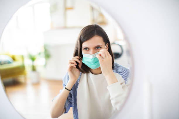 istock Young woman putting on mask before mirror 1312101545