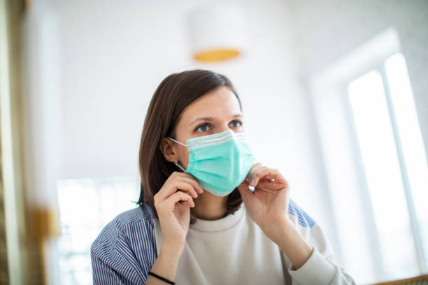 istock Young woman putting on mask before mirror 1312101555