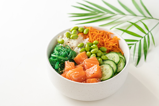 Poké bowl with fresh salmon, rice, chukka salad, edamame beans, carrots and cucumber