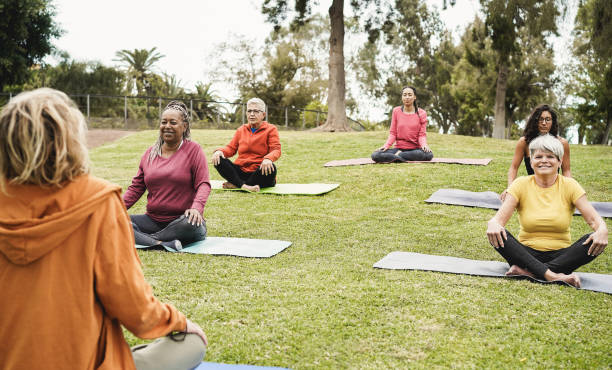 istock People doing yoga class keeping social distance at city park - Focus on front faces 1312102765