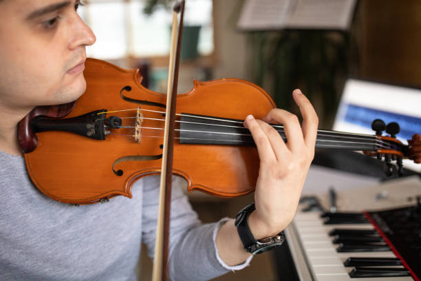 Talented violinist playing violin in music studio at home