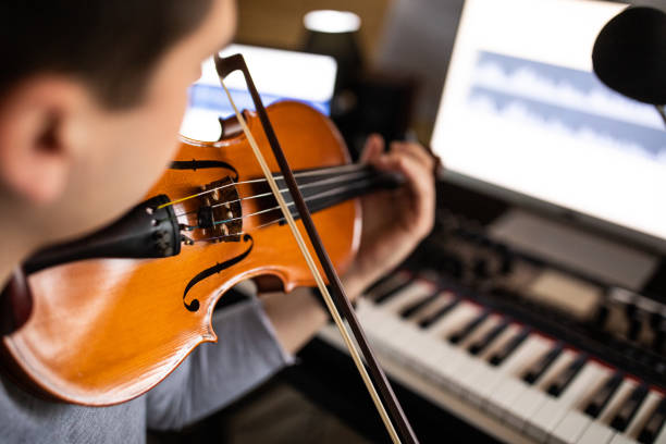 istock Violinist practicing music piece in his music studio at home 1312104856