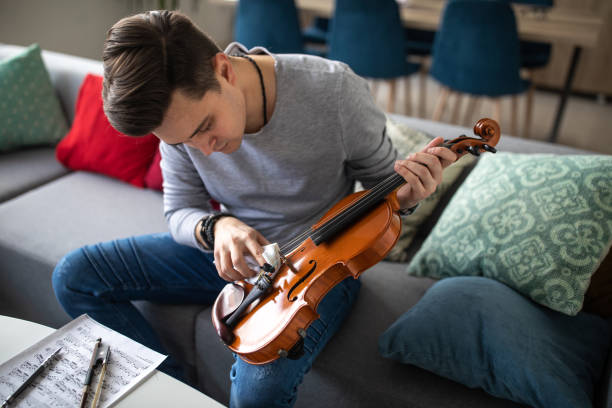 istock Violinist cleaning violin with cloth at home 1312104976