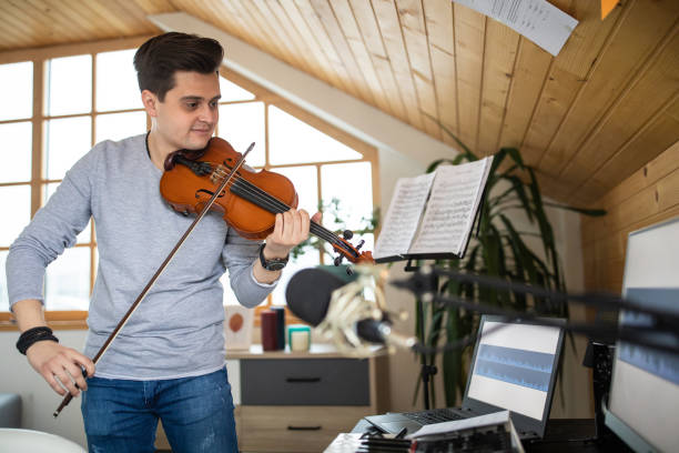 istock Talented violinist playing violin in music studio at home 1312104991