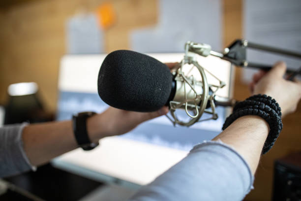 istock Young man adjusting microphone in his home recording studio 1312105024