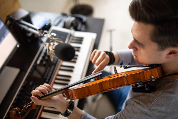 istock Young musician playing violin with Pizzicato technique in his home music studio 1312105210