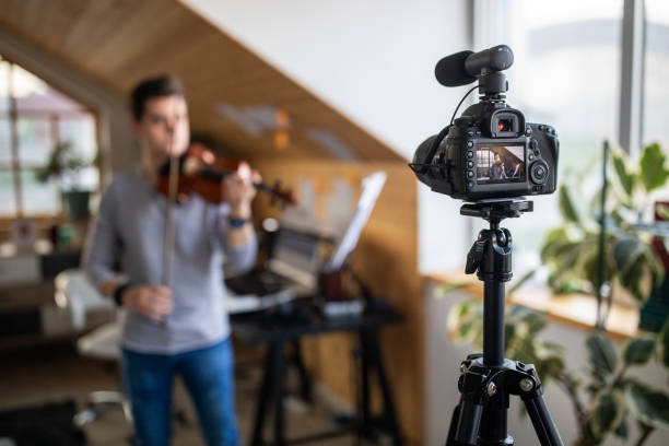 istock Young violinist recording vlog about playing violin at home 1312105355