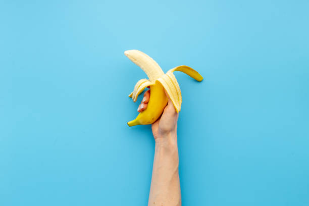 istock Hand holding fresh banana. Fruit background. Top view 1312106181