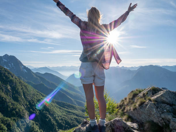 istock Hiker stands arms out on mountain top 1312106336