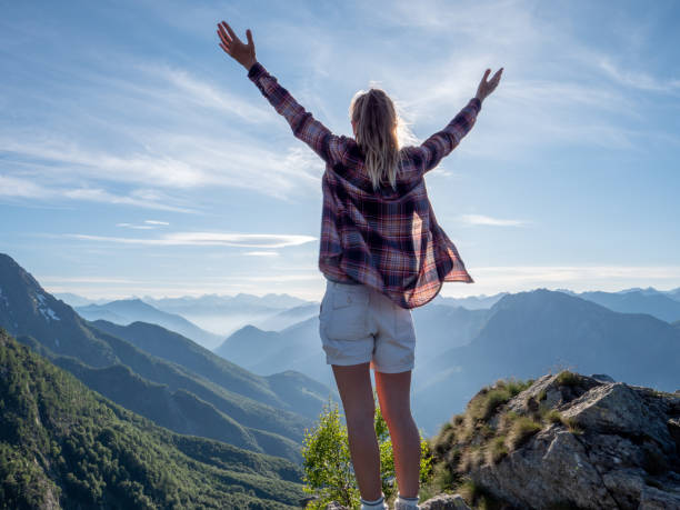 istock Hiker stands arms out on mountain top 1312106382