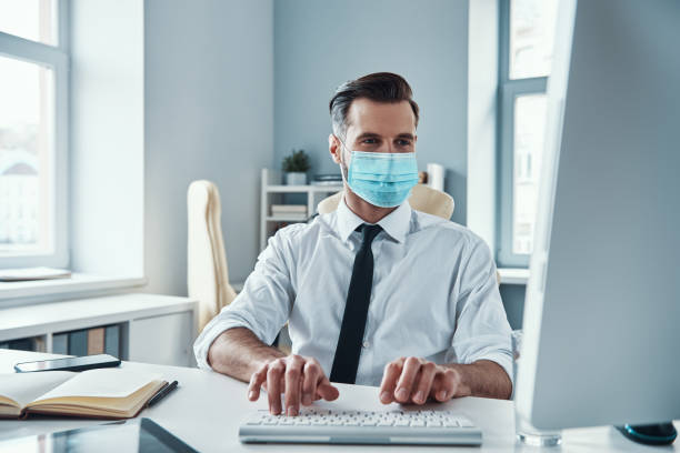istock Confident young businessman in protective face mask 1312106755