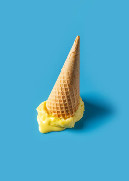 istock Melted yellow ice cream cone creative pastel blue background 1312107888