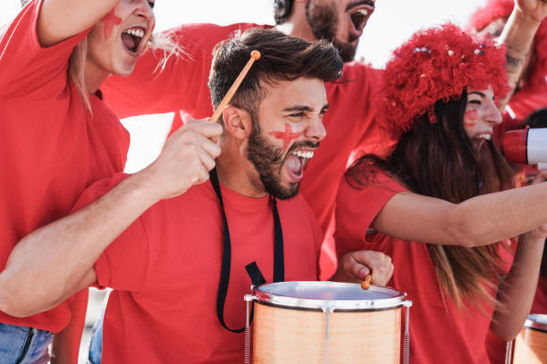 istock Crazy football supporters playing drums and screaming while supporting their team - Focus on man face 1312108818