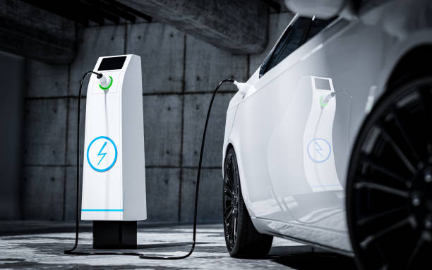 Charging an electric car with a public charger in a parking lot Charging an electric car with a public charger in a parking lot battery charger photos stock pictures, royalty-free photos & images