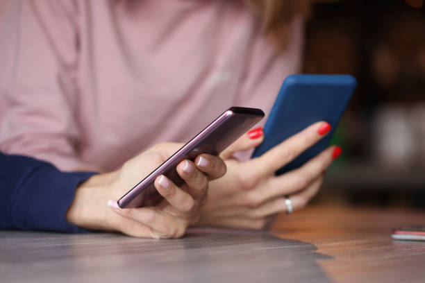 istock Two smartphones in female hands. Chatting closeup 1312112000