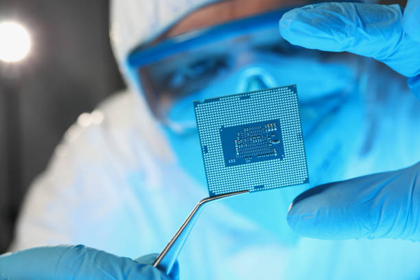 防護服を着た科学者開発者がマイクロ回路を保持 - nanotech ストックフォトと画像