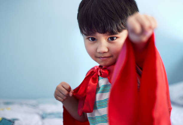 Portrait of an adorable little boy pretending to be a superhero while playing at home