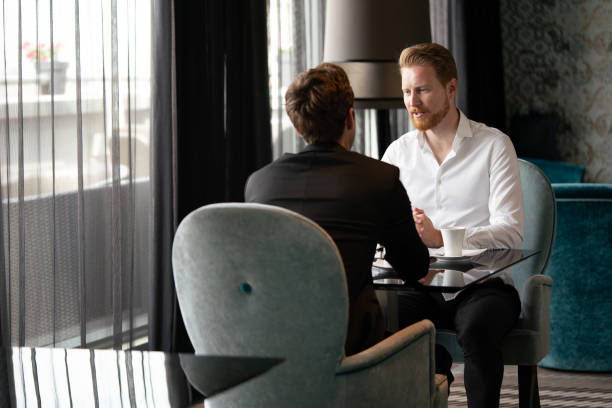 istock Successful businessman smiling while discussing with partner during meeting at coffee break 1312114568