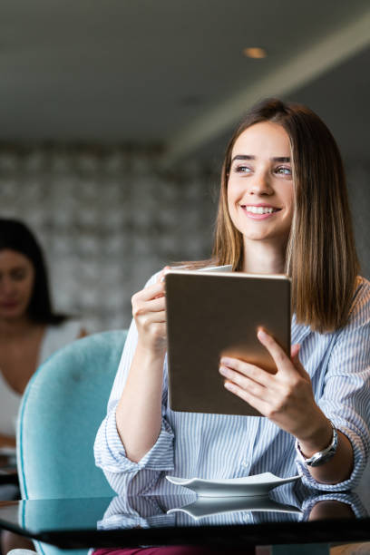 istock Attractive businesswoman using a digital tablet while sitting in cafe 1312114606