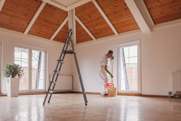 mature painter painting a wall - repairing apartment home improvement painting imagens e fotografias de stock