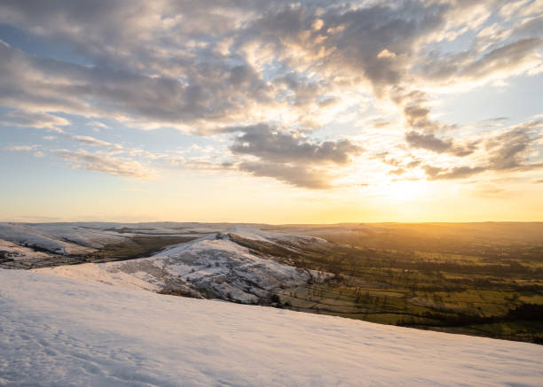 stunning golden winter sunrise over snow covered hill mam tor mountain in derbyshire peak district countryside amazing sky cloudscape. - winter farm vibrant color shadow imagens e fotografias de stock