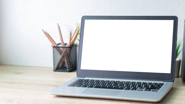 istock Laptop computer with white blank screen on wood desk. Workspace, workplace, desktop office concept. 1312120493