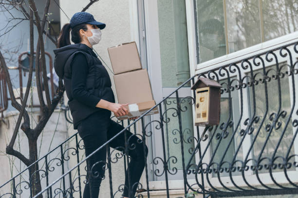 istock Delivery woman delivering cardboard boxes with parcels inside 1312120704