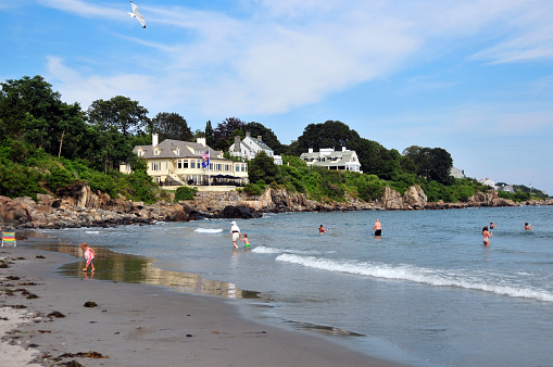 York ME, New England, USA: people in York Harbor Beach and waterfront hotel - small, sandy beach in an otherwise rocky shoreline - Atlantic Ocean.