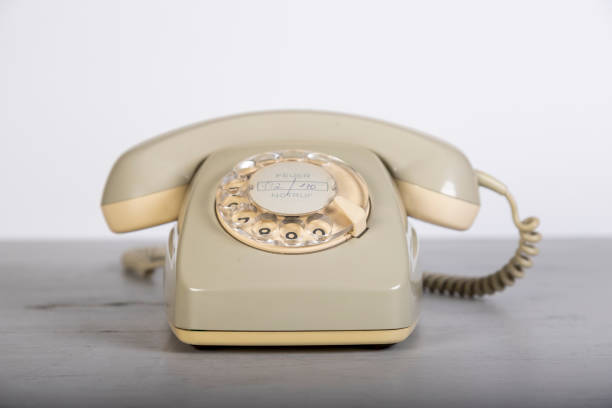 istock old grey telephone with dial plate on a wooden board, white background 1312123690