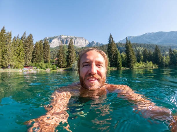 istock Man takes selfie while swimming in alpine lake 1312125561