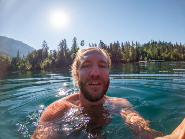istock Man takes selfie while swimming in alpine lake 1312125584