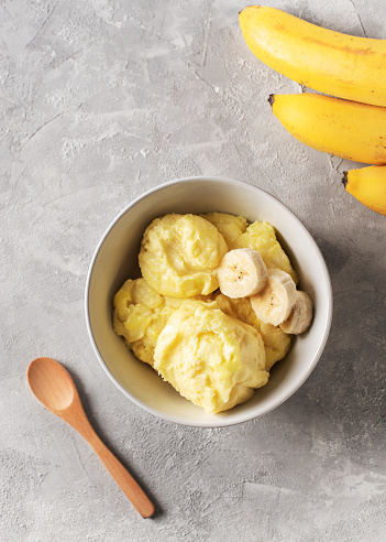Banana homemade ice cream bowl with fruit, vegetarian concept food, copy space, vertical