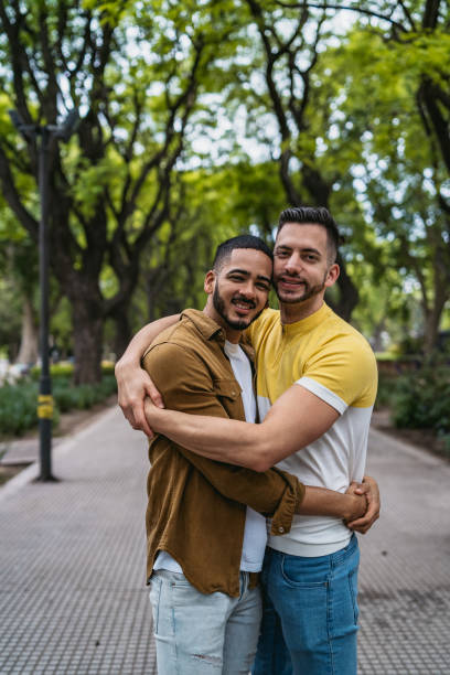 istock Gay couple embracing in park 1312128039