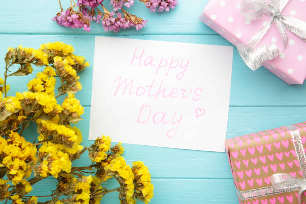 istock Mother's day card with flowers and a present on blue background 1312128243