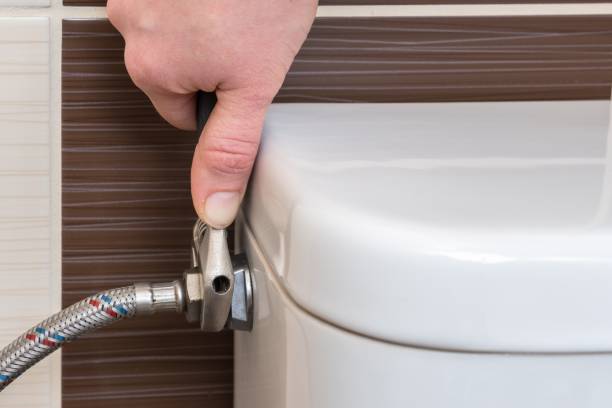 istock Plumber is repairing toilet cistern using a wrench 1312128422